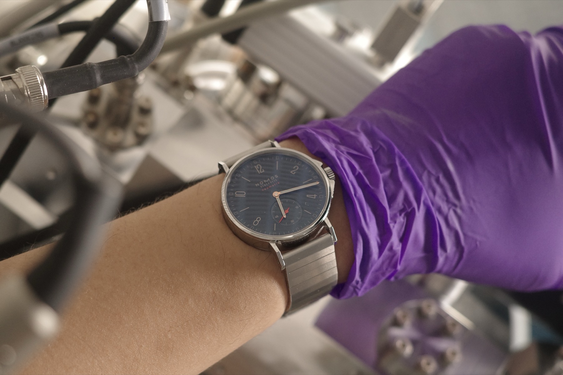 In the lab, gloved hand holding the watch